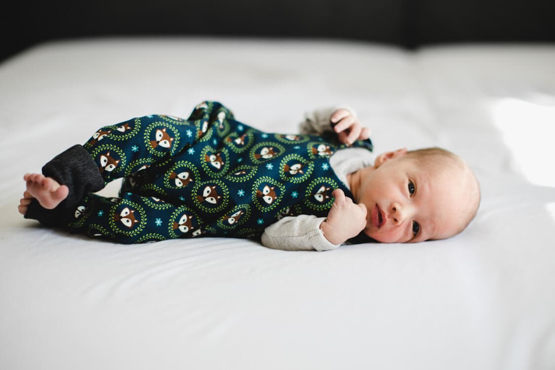 Babyjunge auf dem Bett liegend