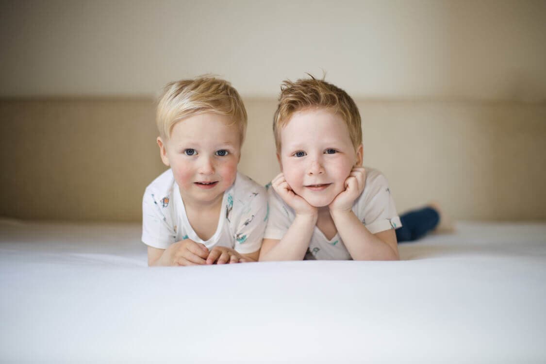 Brüder liegen bäuchlings auf dem Bett