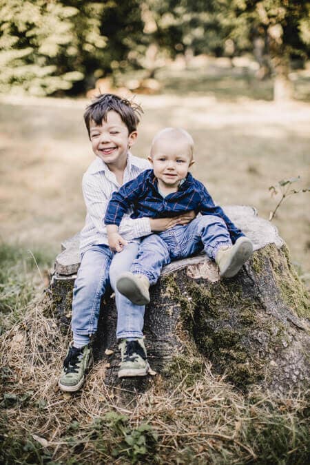 Zwei jungs sitzten auf einem Baumstumpf