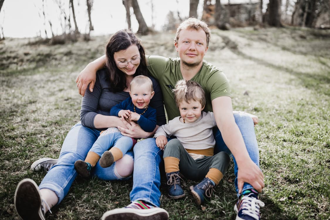 Familie sitzt auf einer Wiese