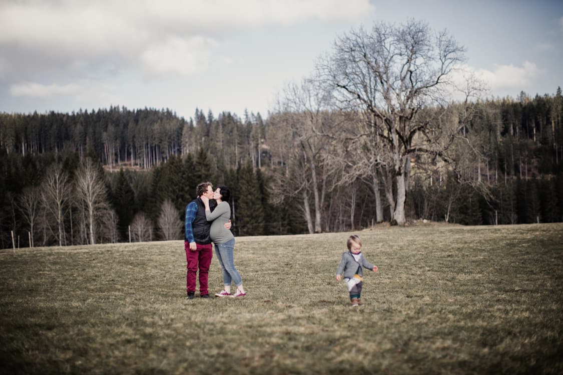 Verliebtes Paar auf einer Wise mit Kind