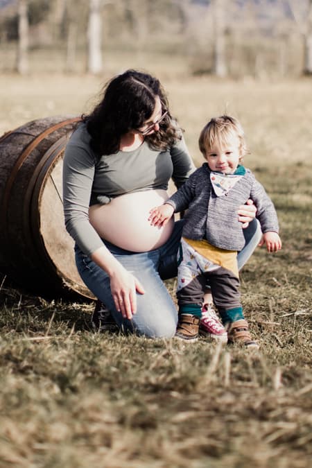 Schwangere Frau mit Sohn vor einem Weinfass