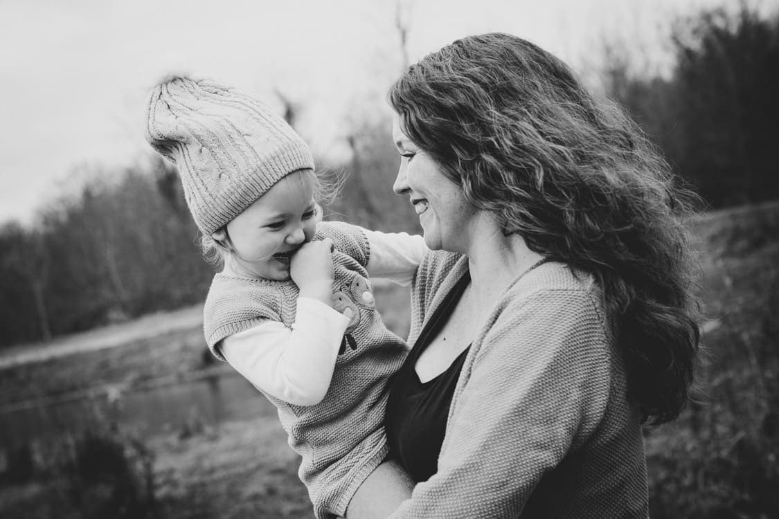 Mama mit Tochter auf dem Arm in Bewegung