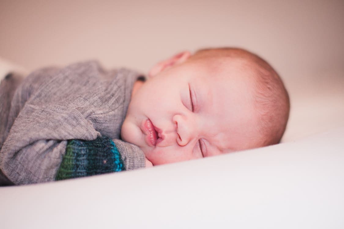 Baby liegt bäuchlings auf dem Bett