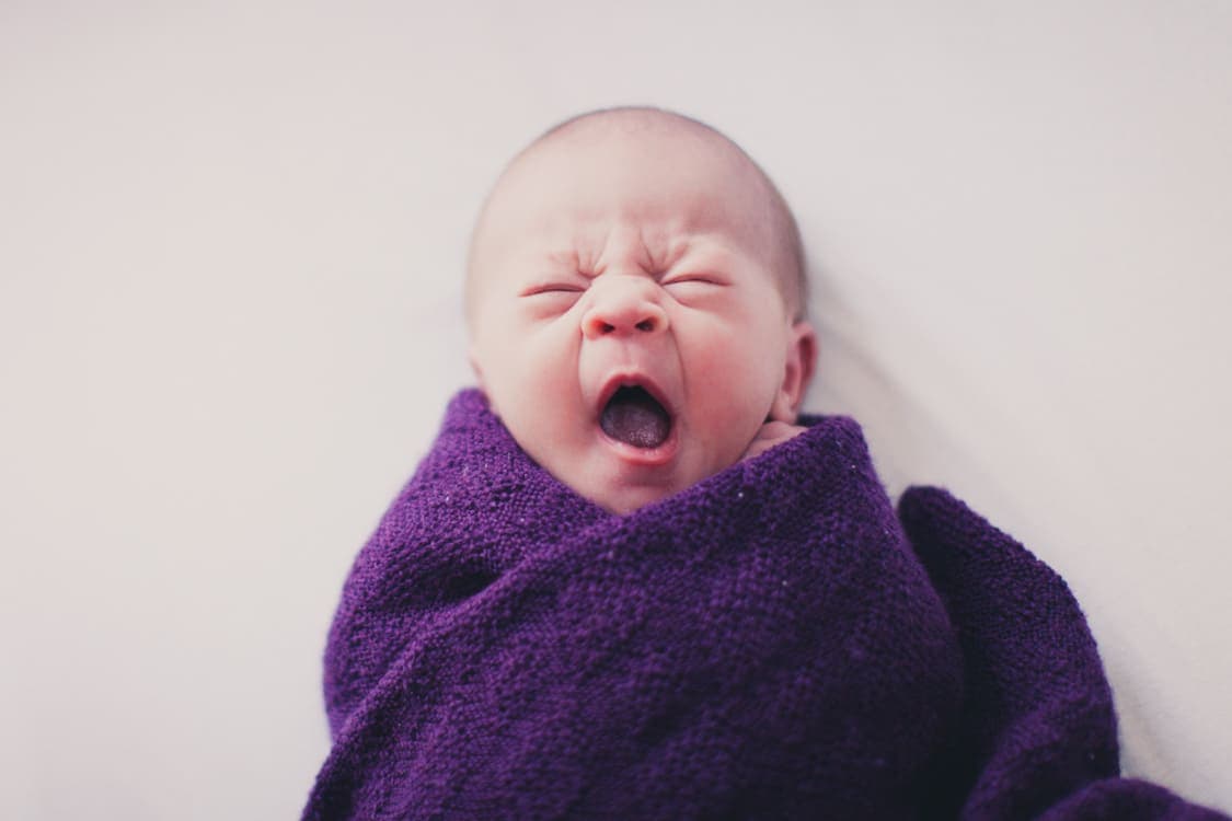 Baby eingepuckt gähnt 