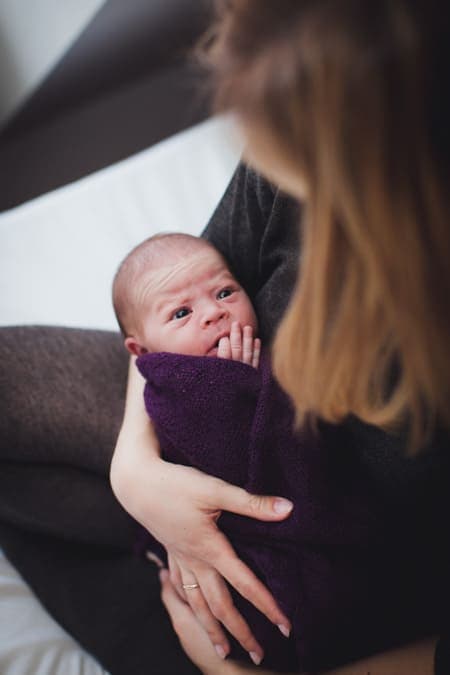 Baby eingepuckt liegt bei Mama auf dem Arm