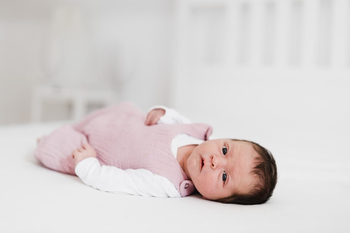 Baby Mädchen liegt auf dem Bett