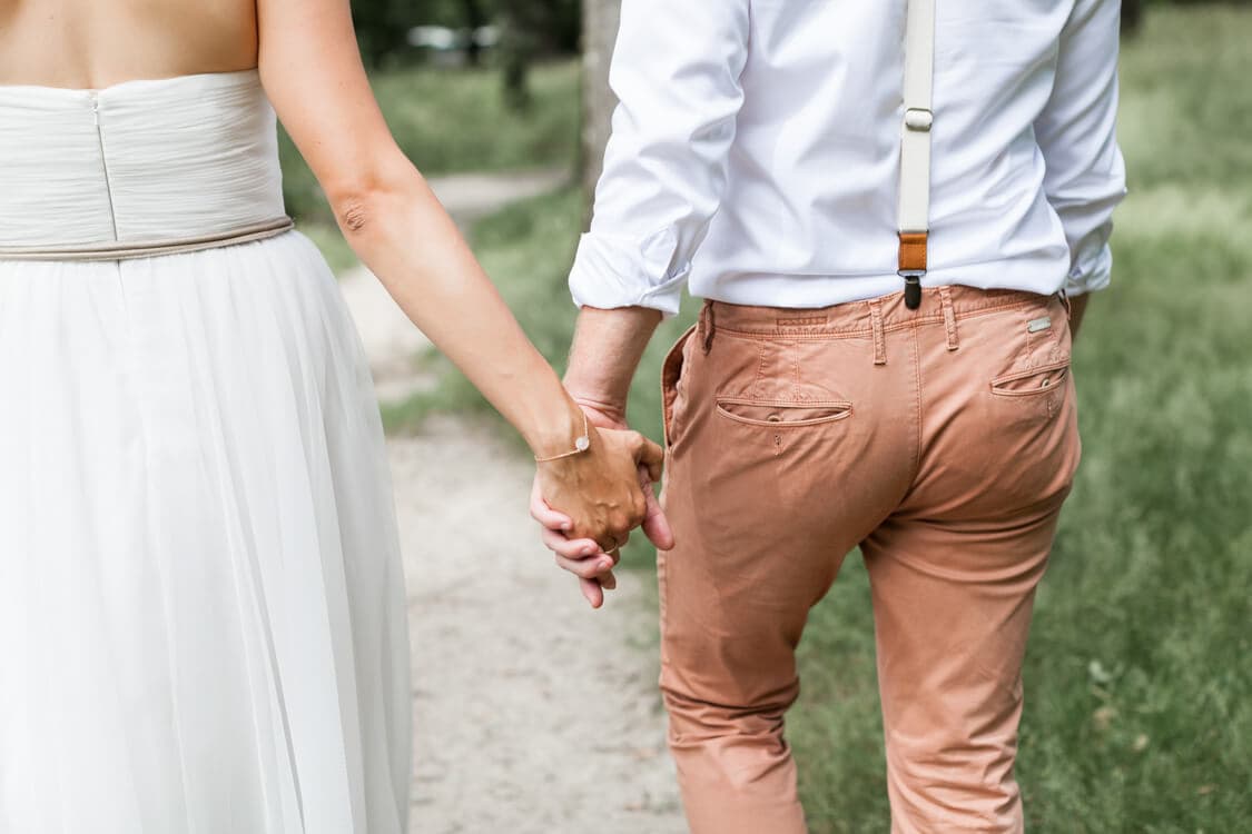 Nahaufnahme von den Brautpaarhänden Hand in Hand