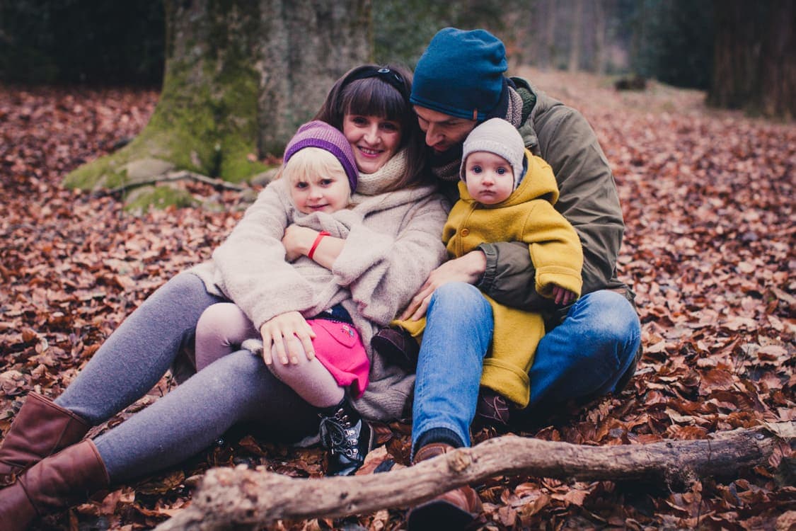 Familie sitzt auf dem Boden voller Blätter