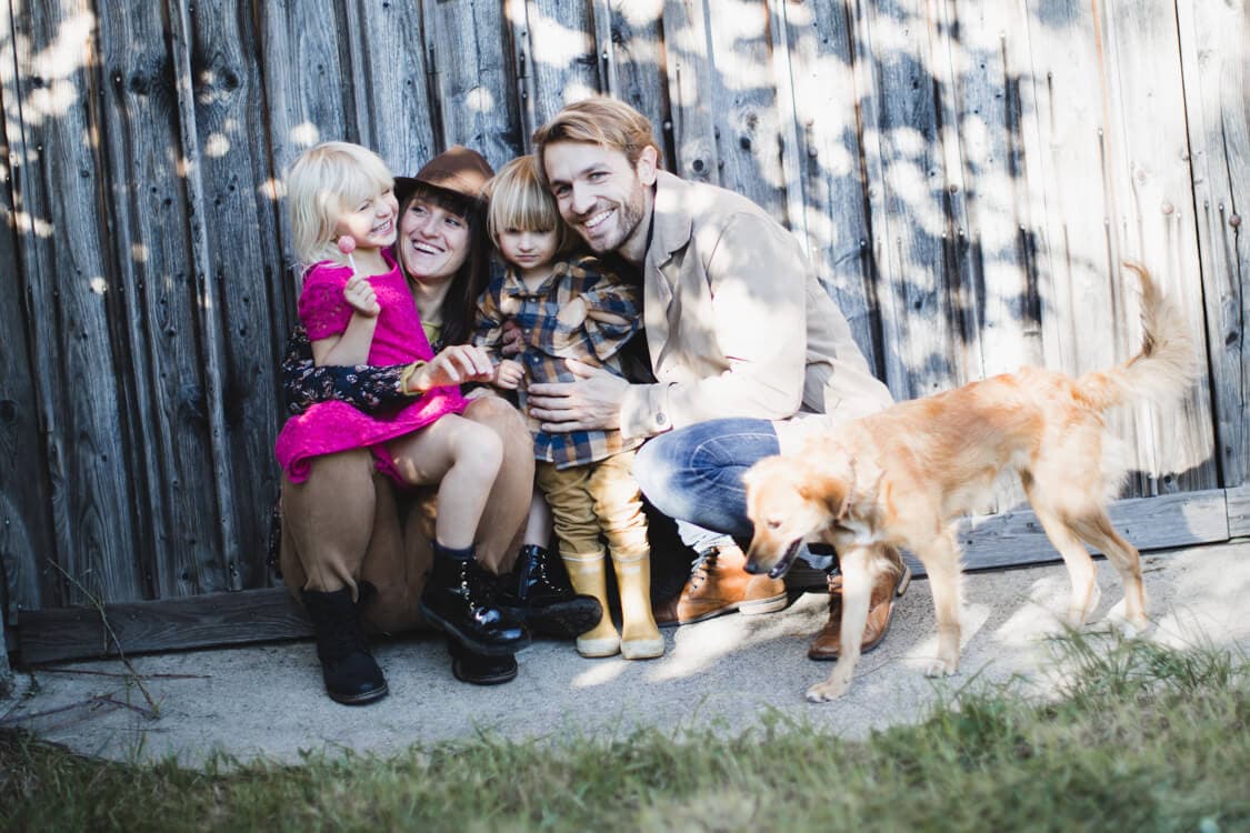 Familie mit Hund vor einem Scheunentor
