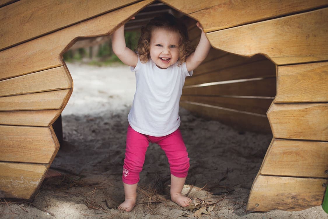 Mädchen guckt aus Spielhütte raus