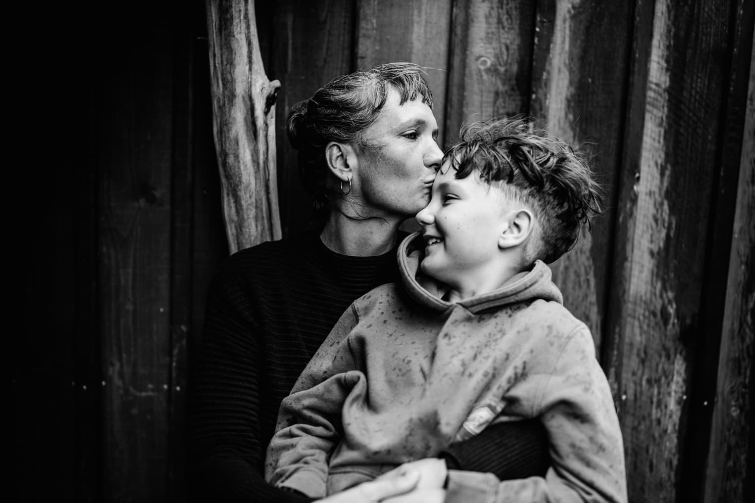 Mutter küsst ihren Sohn auf die Stirn