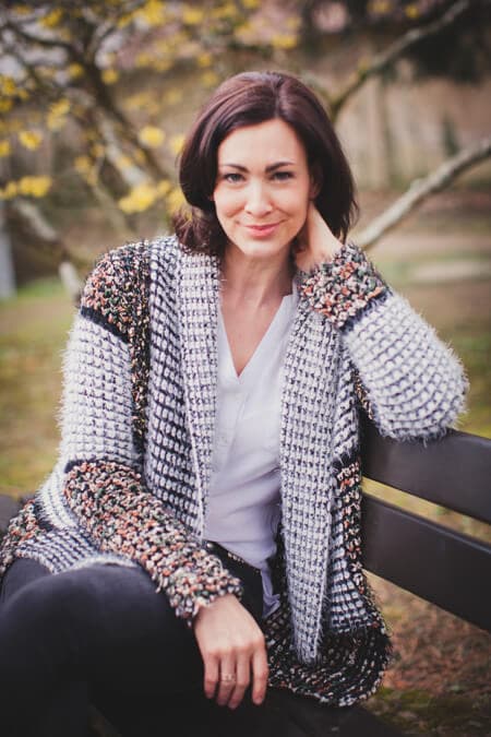 Frau sitzt auf einer Bank und stützt ihren Kopf in ihrer Hand