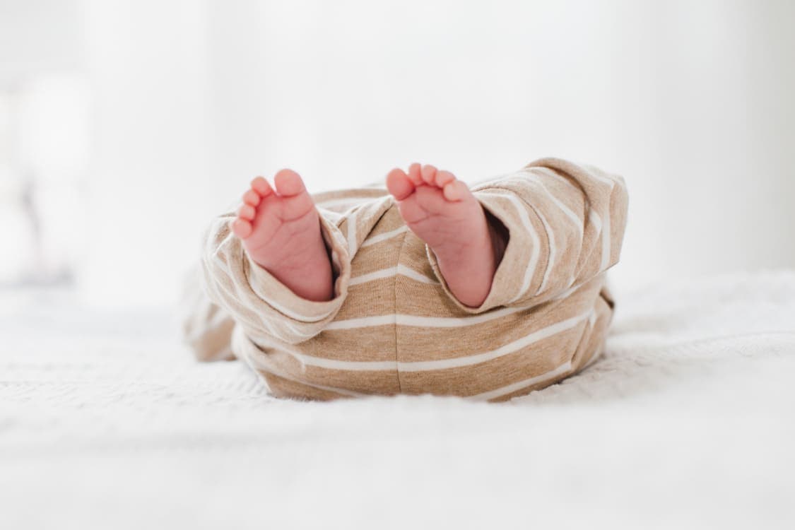 Babyfüßchen von Baby mit gestreiftem Strampler