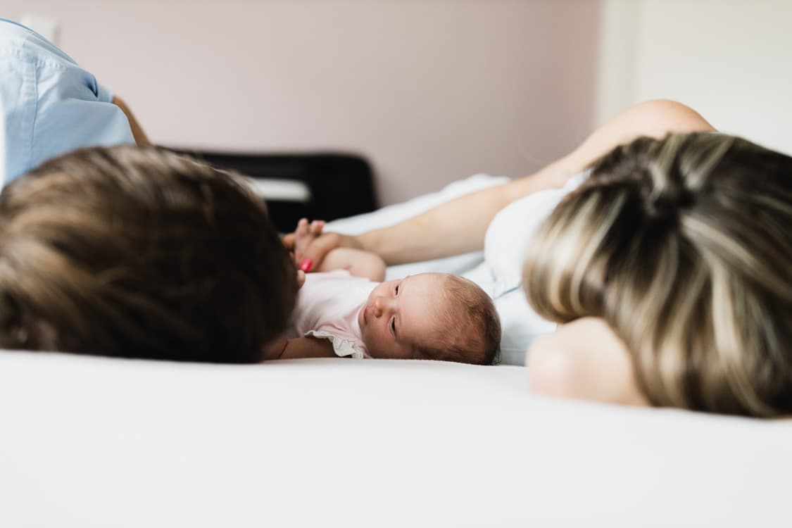 Eltern auf dem Batt mit Baby