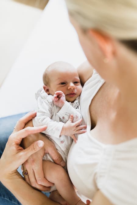 Neugeborenes uf dem Arm der Mutter
