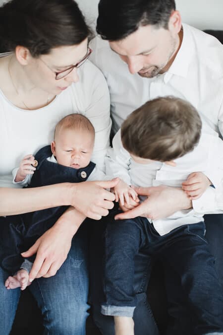 Eltern haben ihre beiden Kinder auf dem Schoß