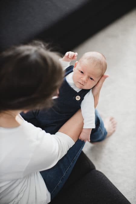 Blick von oben auf Baby im Arm der Mutter