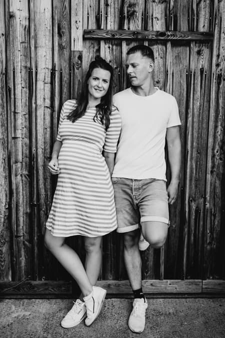 Paar lehnt an Scheunentor