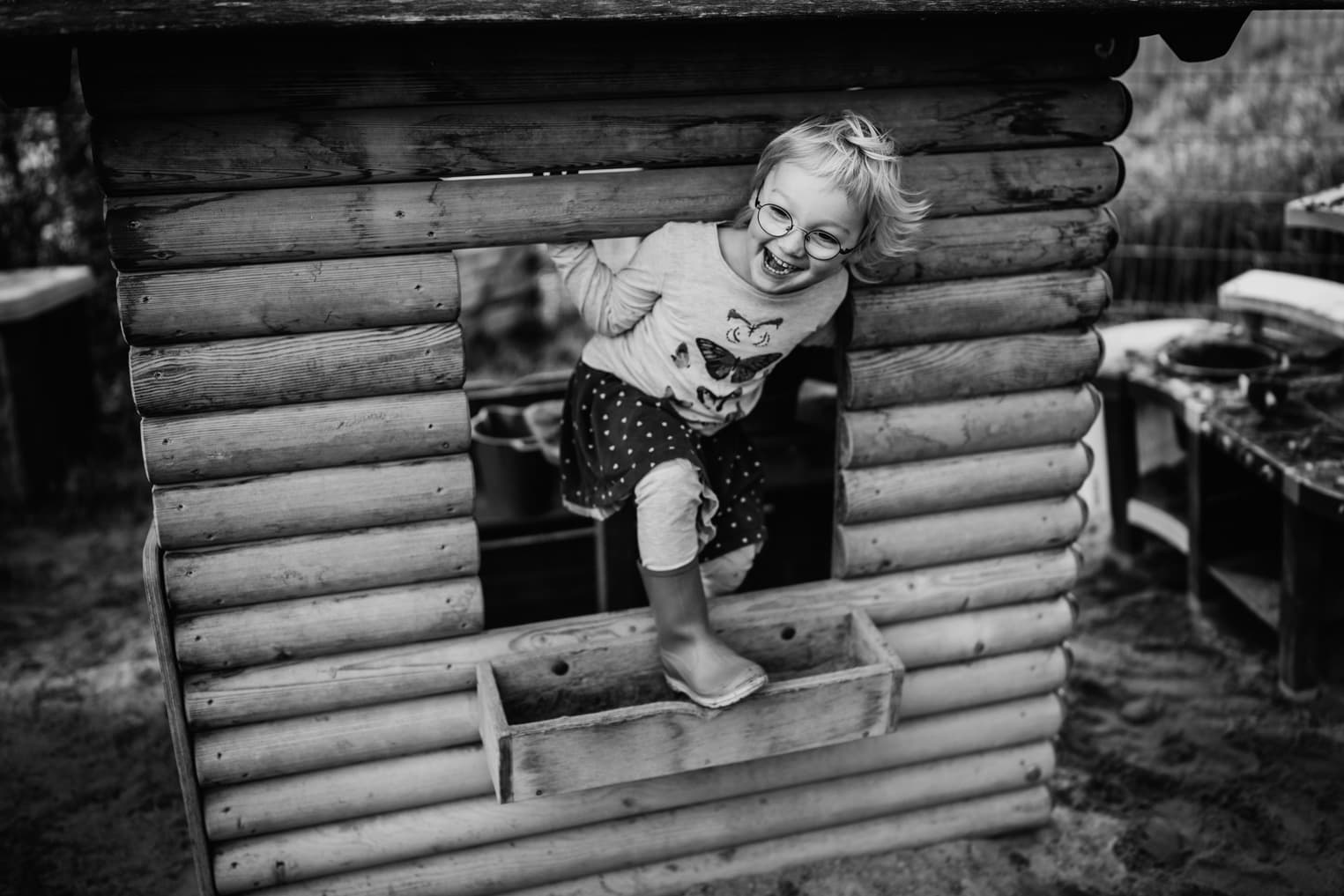 Mädchen mit Stock auf einem Klettergerüst