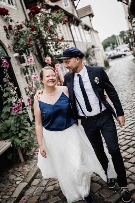 Brautpaar geht durch eine schoene Gasse