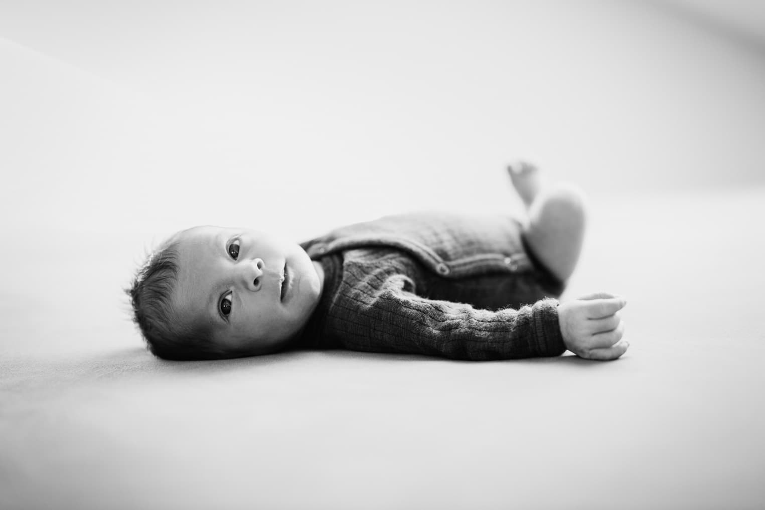 Baby liegt auf einem Bett