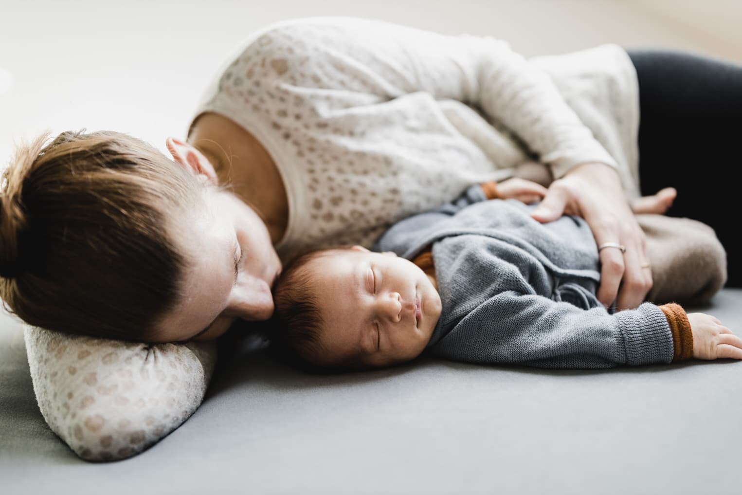 Mutter küsst ihr Baby auf den Kopf
