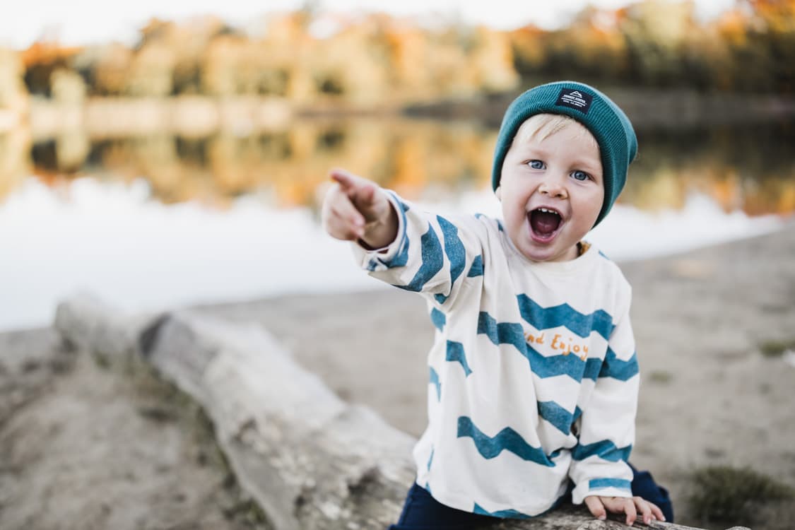 Junge auf Baumstamm am See