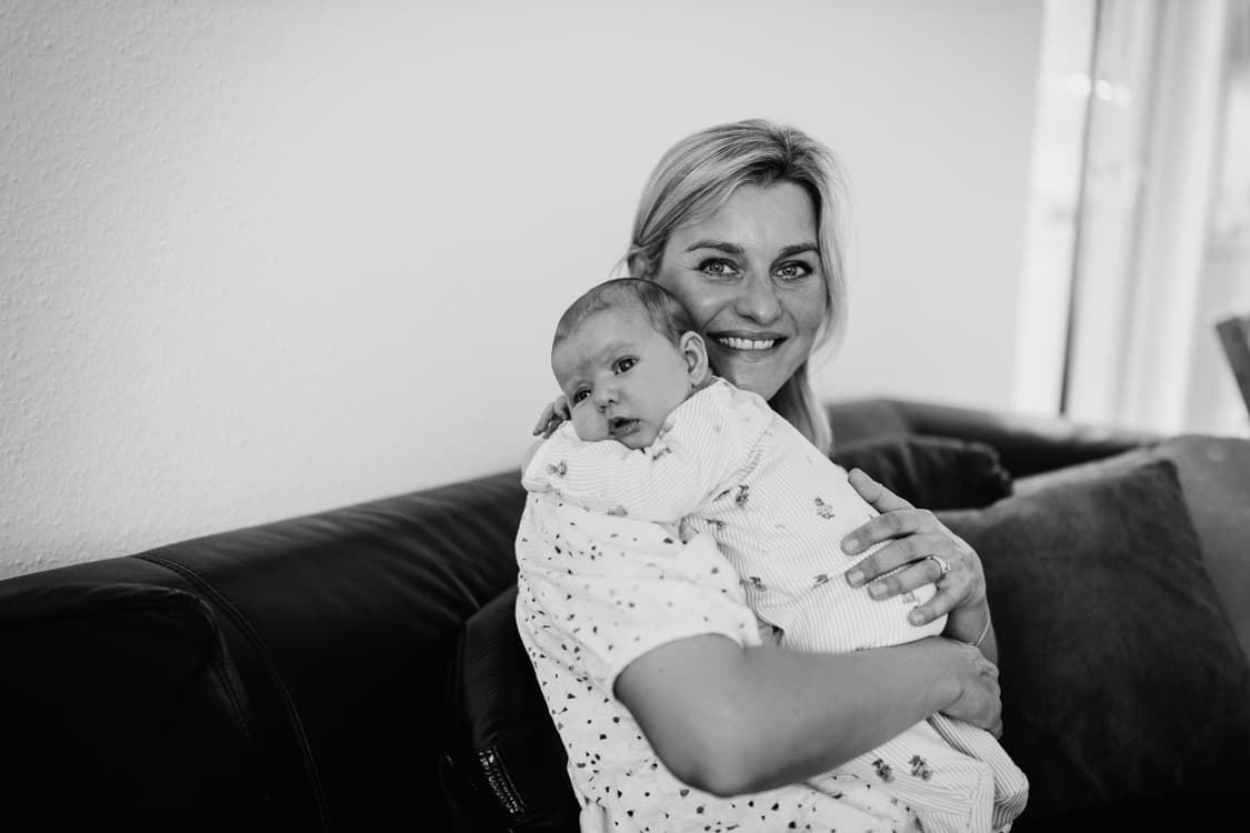 Baby liegt über der Schulter der Mutter