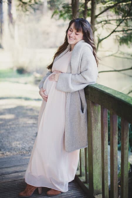 Frau auf einer Brücke mit Babybauch