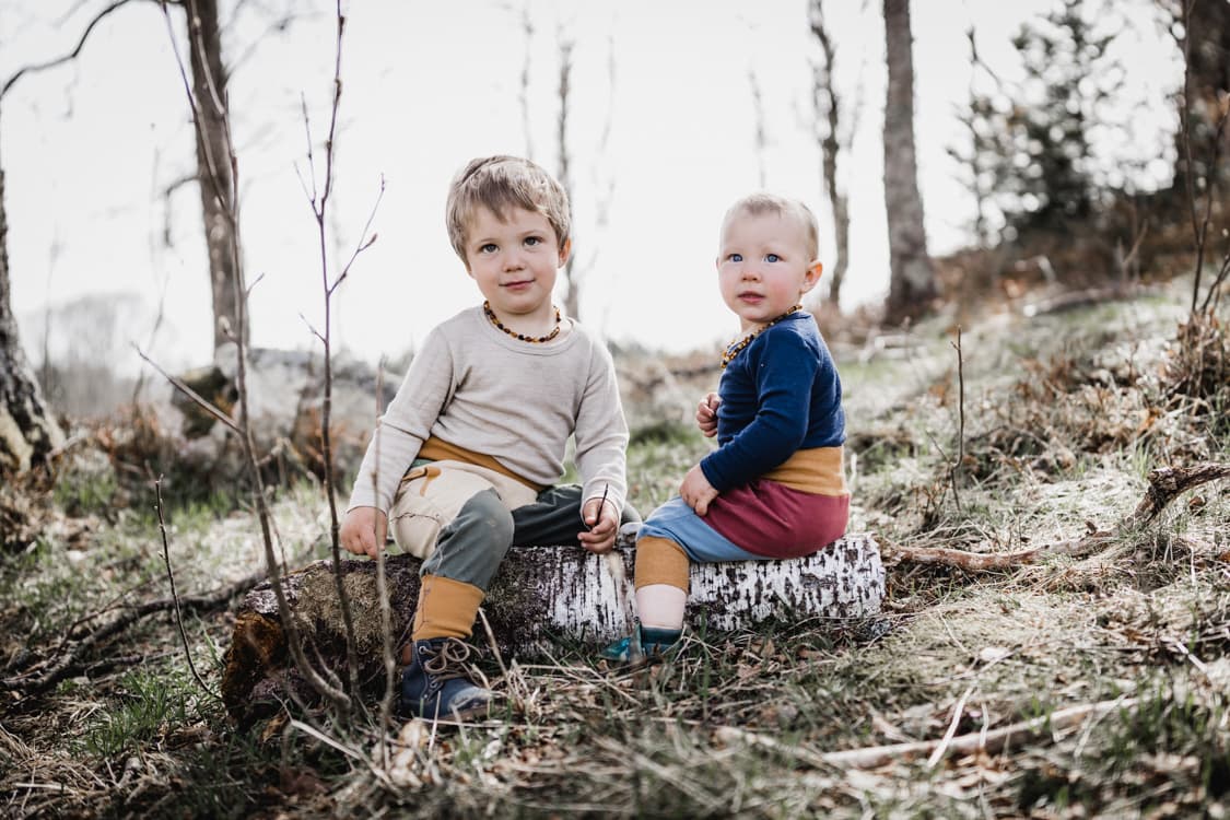 Geschwister sitzen auf einer Wiese
