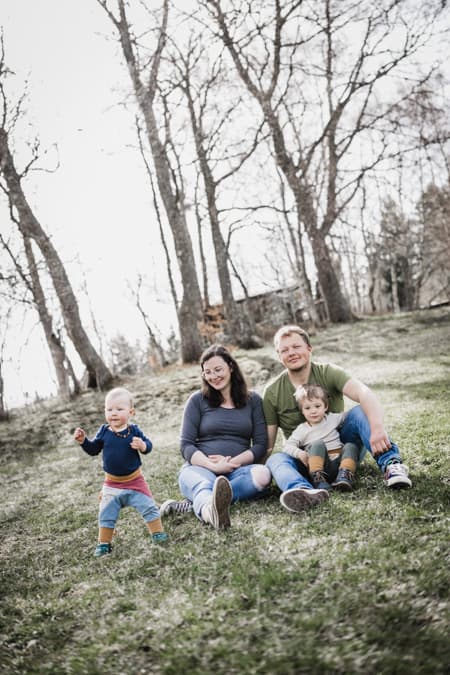 Familie sitzt auf einer Wiese