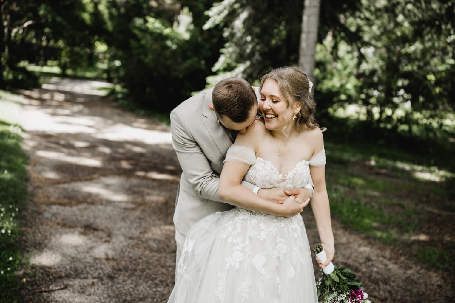 Bräutigam umarmt Braut von hinten, sie lacht romantisches Hochzeitsfoto Freiburg