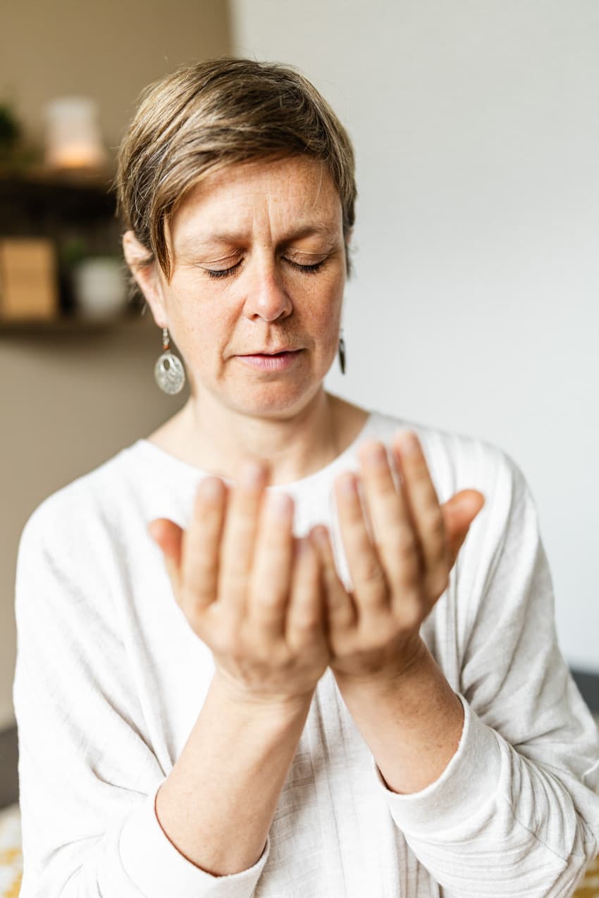 Frau riecht an den Händen, Nahaufnahme im Yoga-Studio, natürliche Business-Fotografie