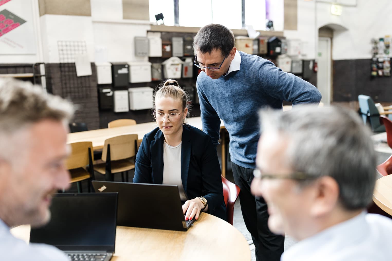 Business Fotografie aus Freiburg mit Führungskraft, die Mitarbeitende bei der Arbeit am Laptop begleitet