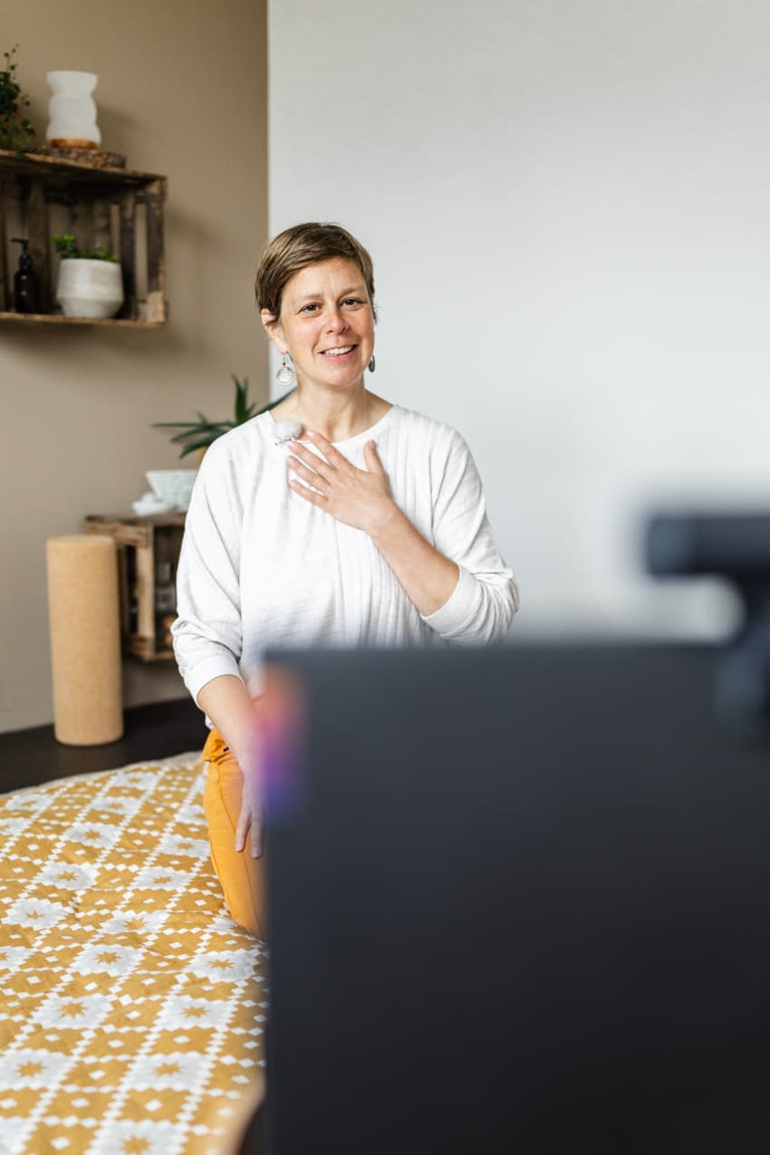 Yogalehrerin beim Online-Kurs am Laptop, authentische Aufnahme für Homepage und Image-Bilder