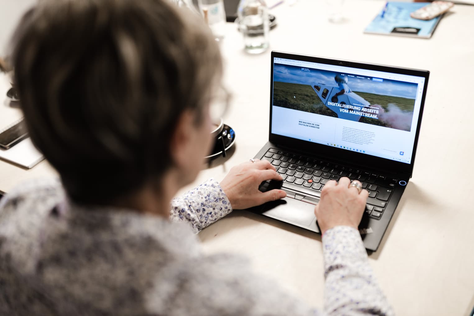 Authentische Business Fotografie aus Freiburg mit einer Frau, die konzentriert am Laptop im Büro arbeitet