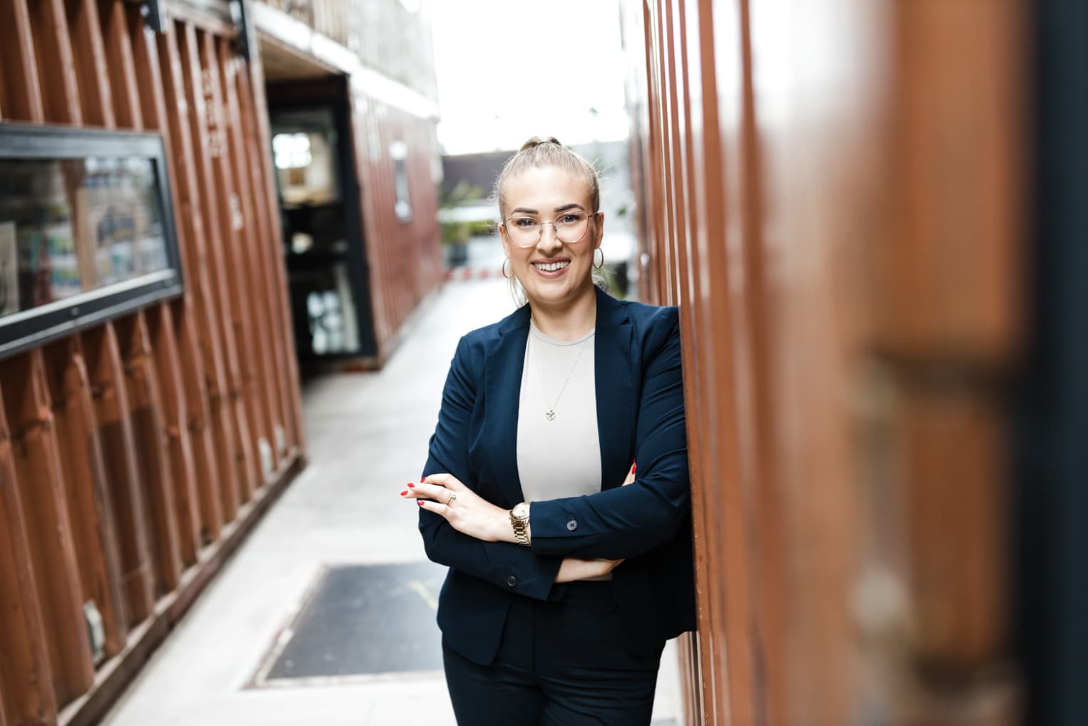 Professionelles Business Portrait aus Freiburg mit sympathischer Geschäftsfrau an einer rostroten Wand