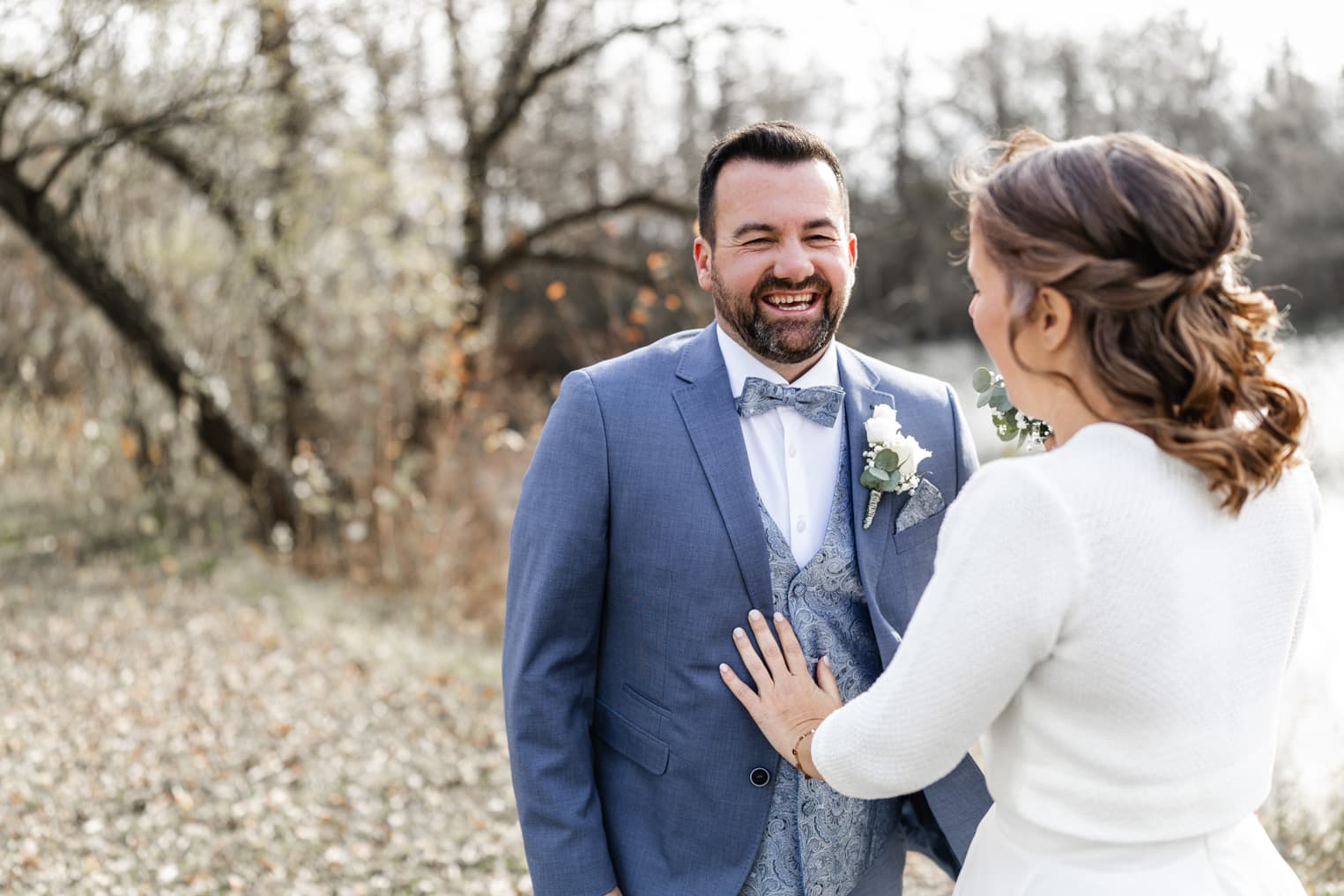 Bräutigam lacht voller Freude beim ersten Anblick seiner Braut