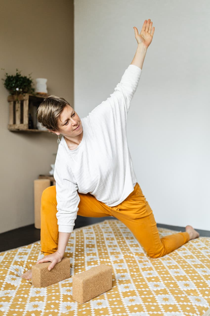 Frau macht Yogaübung auf Matte im Studio, lebendige Pose für Homepage-Bilder