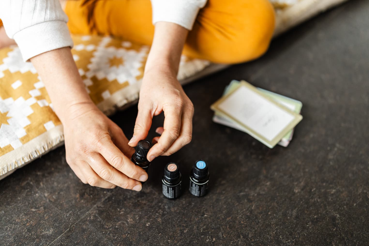 Frau öffnet Duftöle im Studio, Fokus auf Fläschchen, authentische Image-Aufnahme