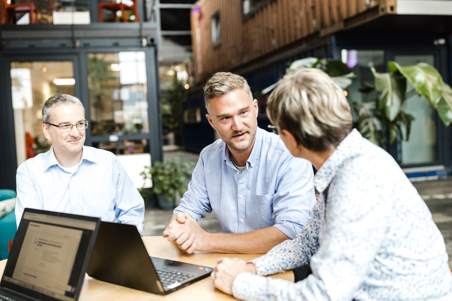 Business Fotografie aus Freiburg zeigt Teamarbeit, Arbeitskollegen besprechen Inhalte am Laptop
