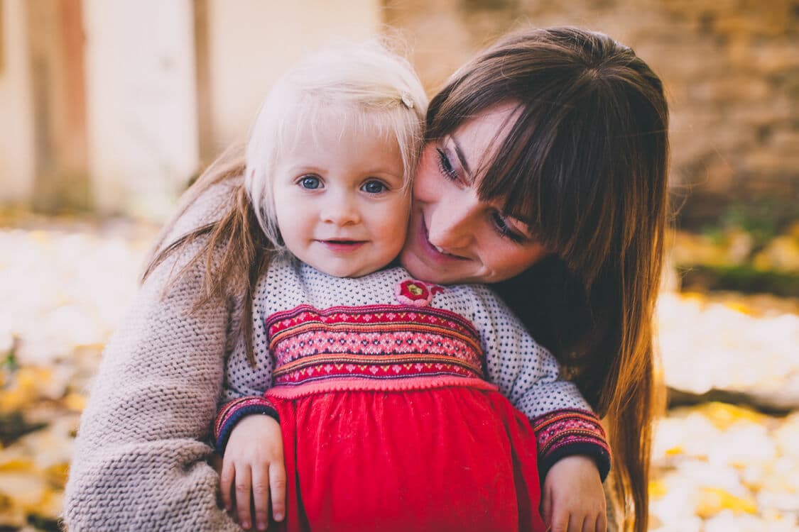 Mädchen lehnt sich an Mama an