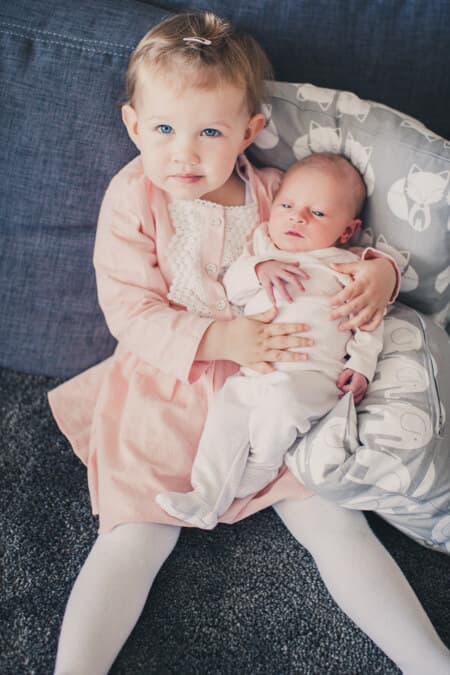 Große Schwester mit kleiner Schwester auf dem Schoß